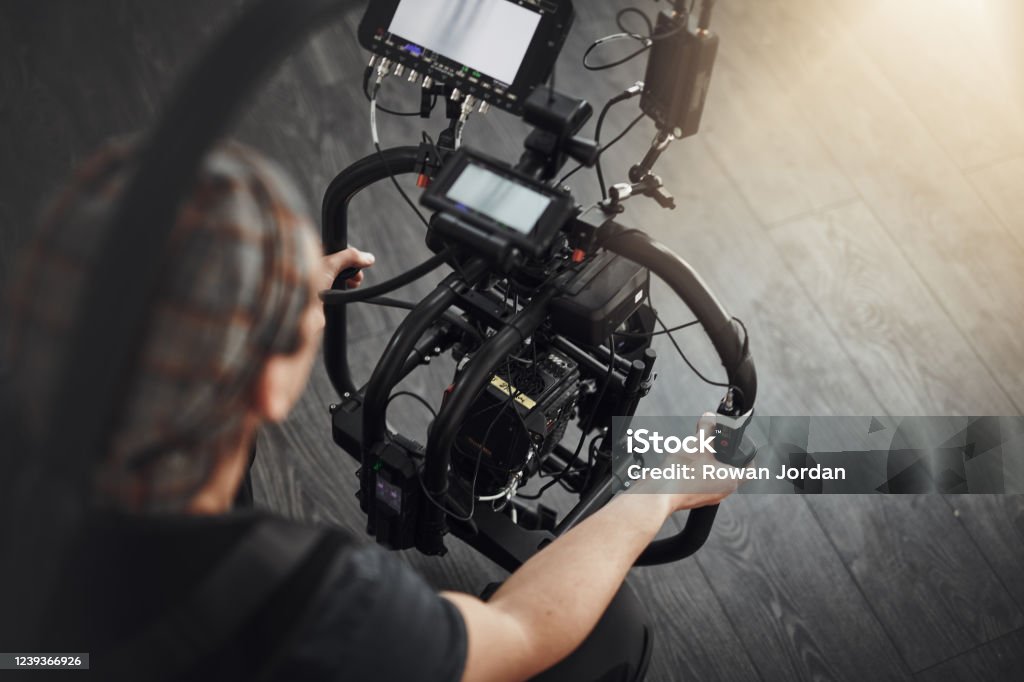 Hold it steady Behind the scenes shot of a camera operator shooting a scene with a state of the art camera inside of a studio during the day Movie Stock Photo