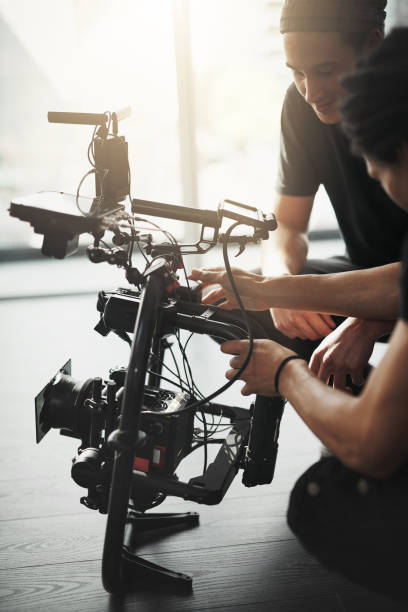 Pay attention to detail Behind the scenes shot of two young camera operators shooting a scene with a state of the art camera inside of a studio during the day stage set photos stock pictures, royalty-free photos & images