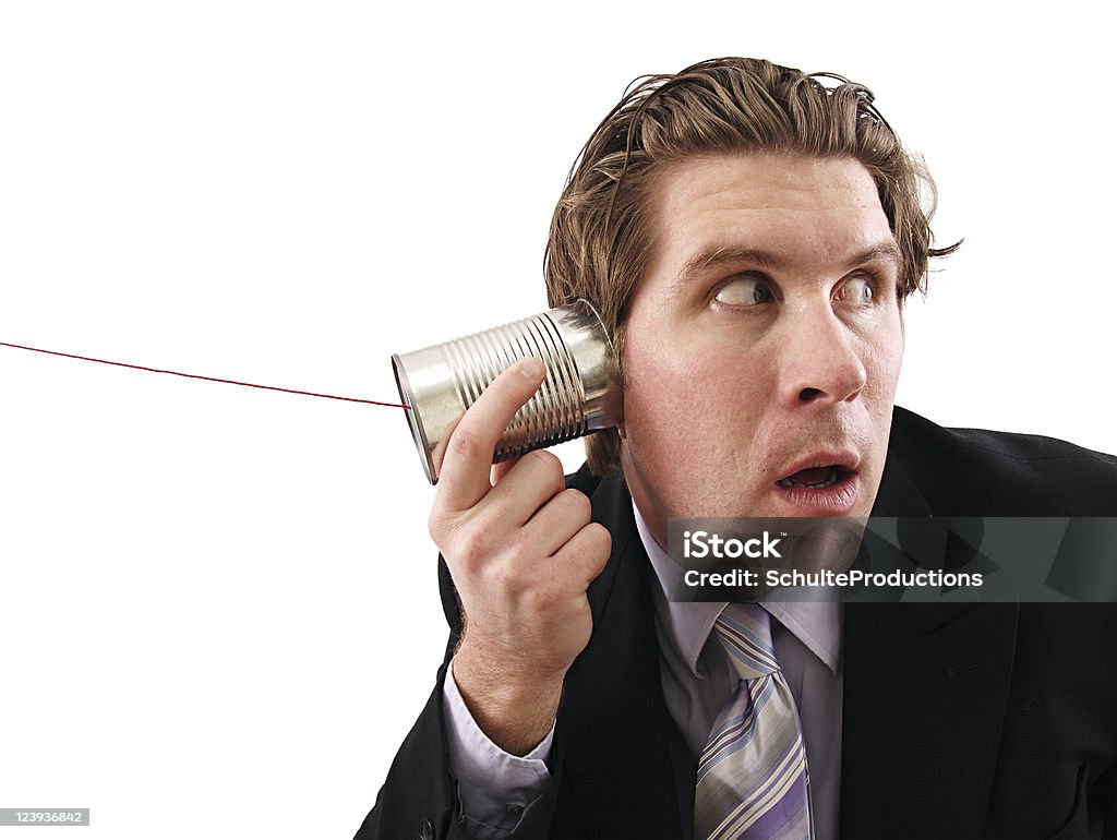 Can Phone Businessman a businessman listening on his can phone isolated on white. Adult Stock Photo