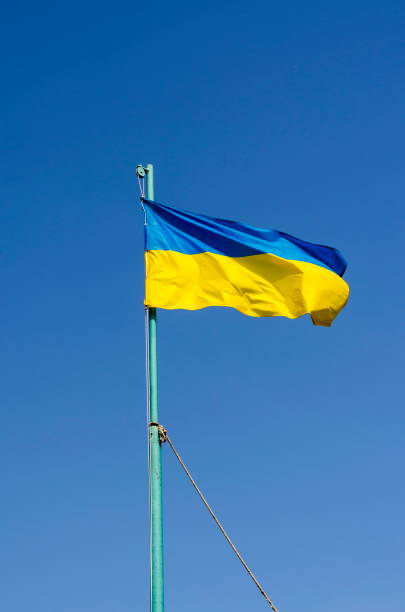 istock Ukrainian flag flying on a flagpole in against the blue sky. 1239375497