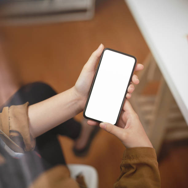 istock Female freelancer holding mock-up smartphone on blurred office room background 1239382927