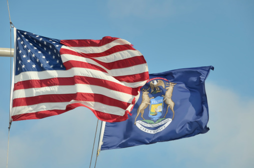 Wyoming flag on a flagpole waving in the wind, blue sky background. 3d illustration.