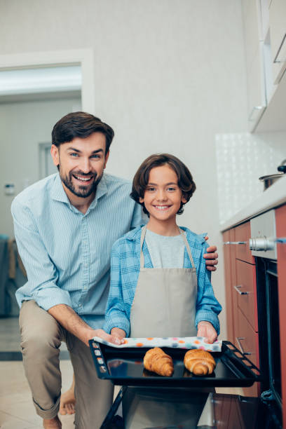 istock Mirthful father and son enjoying cooking in free time 1239387766