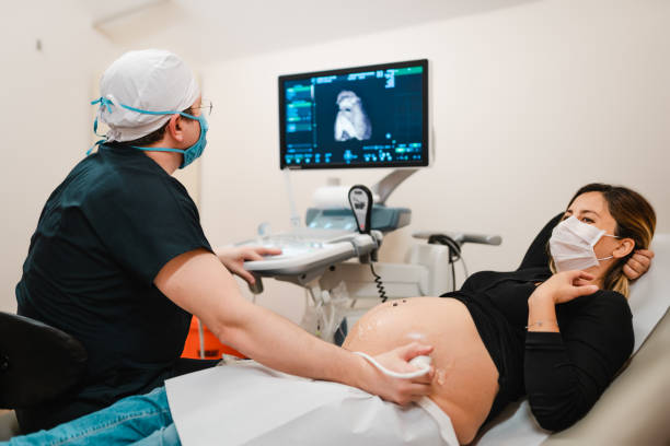 mujer embarazada observando a su bebé en la ecografía - gynecologist gynecological examination ultrasound human pregnancy fotografías e imágenes de stock