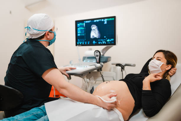donna incinta che guarda il suo bambino sull'ecografia - ultrasound gynecologist gynecological examination human pregnancy foto e immagini stock