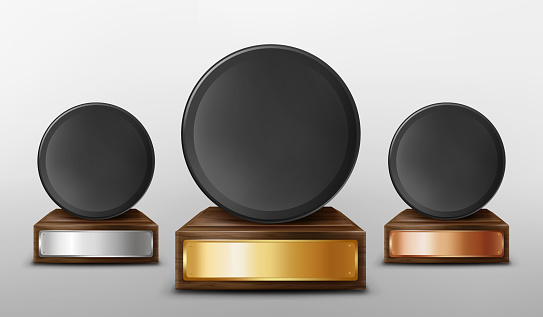 Realistic 3d vector illustration of trophy cups. Black pucks on wooden stand with gold, silver, bronze empty plates, isolated on white background. Award prize for victory in ice hockey competition,