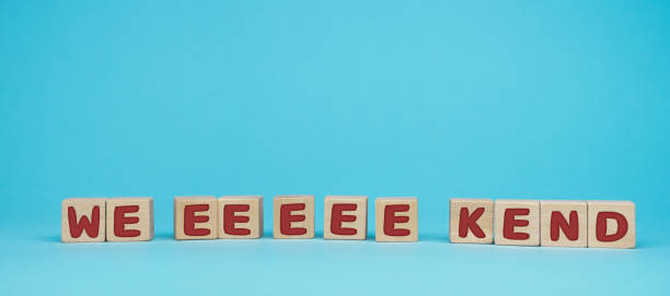word weekend written on wood block. Have a wonderful weekend text on blue background
