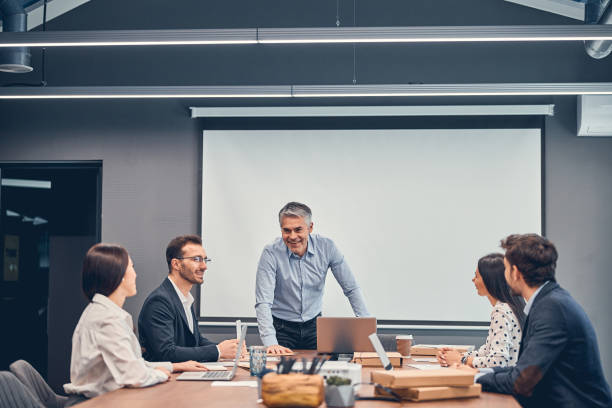 istock Smiling colleagues discussing new startup project with boss in office 1239433564