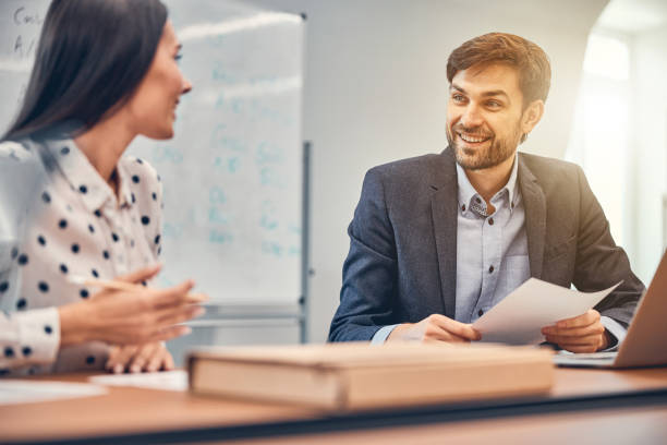 istock Happy colleagues working in office and looking each other 1239434082
