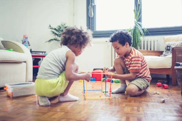 istock Little brother and sisters playing with color straws 1239434678