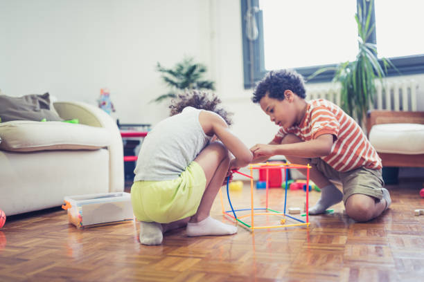 istock Little brother and sisters playing with color straws 1239434711
