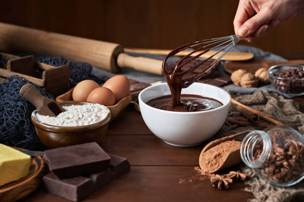 kuvapankkikuvat ja rojaltivapaat kuvat aiheesta nainen tekee suklaamoussea ja keksejä puupöydällä maalaismaisessa keittiössä - mousse dessert