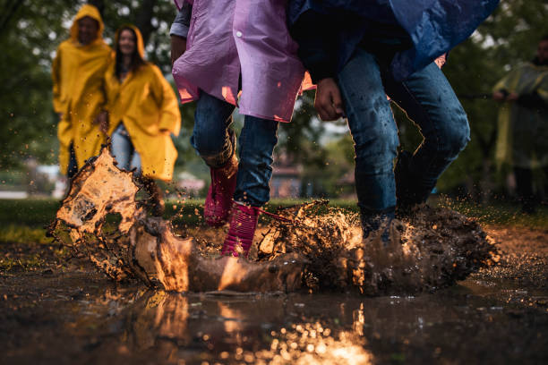 istock Unrecognizable kids running through muddy puddle in nature. 1239454767