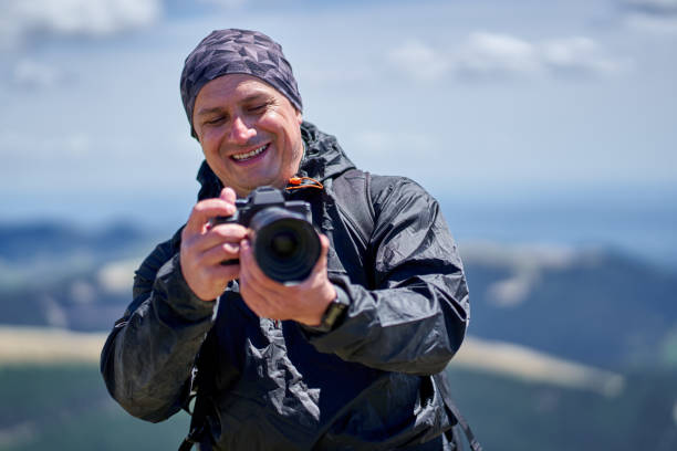 istock Man with camera in the mountains 1239455314