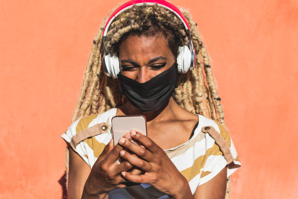 istock Yound african woman with blond dreadlocks using mobile phone while listening playlist music - Trendy person having fun with technology trends - Tech, lifestyle and social media concept 1239463203