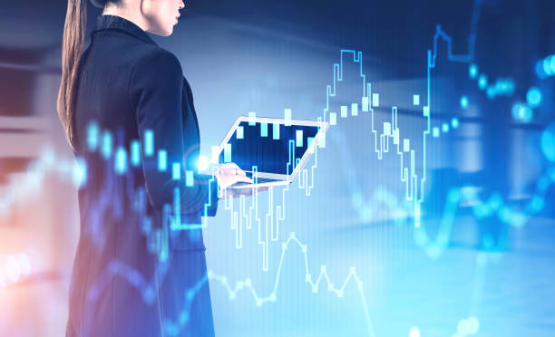 istock Woman with laptop in office, financial graph 1239464901