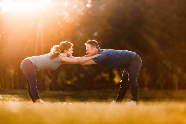istock Happy athletic couple cooperating while exercising in nature. 1239466064