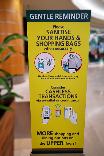 A poster signage disseminate information - encourage shoppers to sanitise and cashless transaction is preferred in Malaysia.