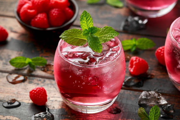 istock Refreshing raspberry cocktail with ice and mint on wooden table 1239469961