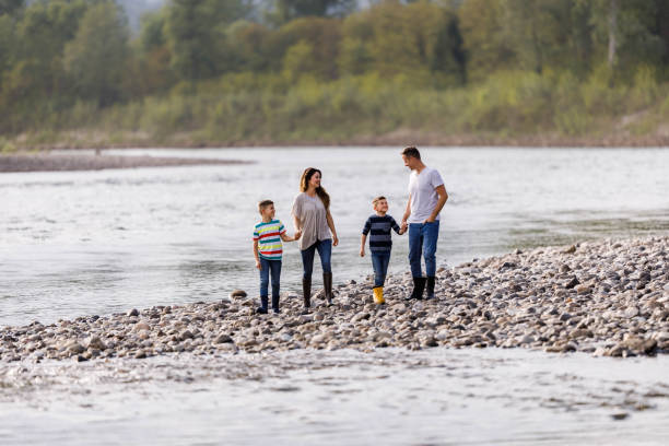 istock Young happy family talking while enjoying in their walk by the river. 1239470478