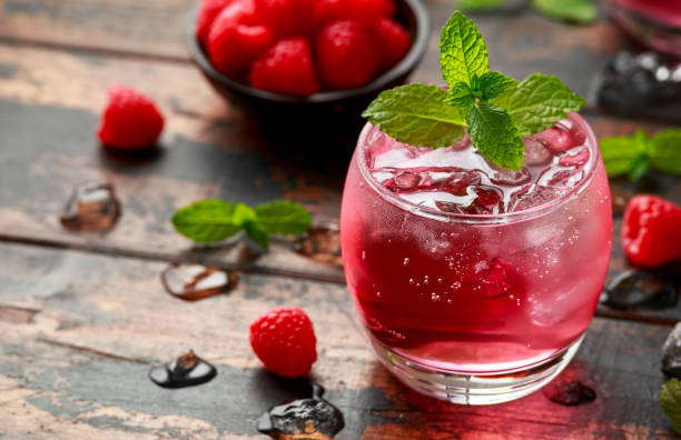 istock Refreshing raspberry cocktail with ice and mint on wooden table 1239471551