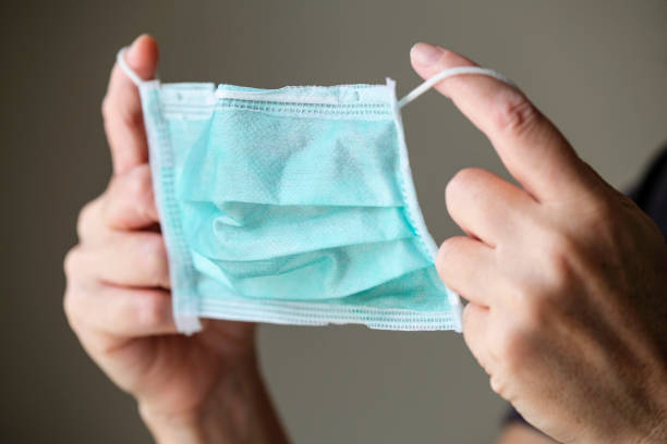 istock Woman putting on a protection mask 1239472089
