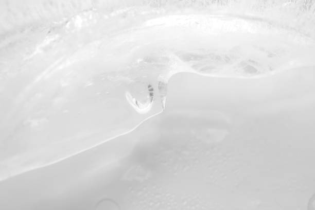Macro ice texture with selective focus. Frosted water on white background. Summer cold abstract defocused wallpaper