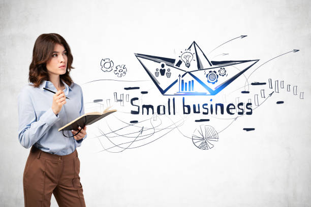 Woman with notebook, small business sketch Serious young businesswoman with dark wavy hair and notebook standing near concrete wall with creative small business sketch drawn on it. Concept of business strategy and education Master’s Degree in Marketing stock pictures, royalty-free photos & images