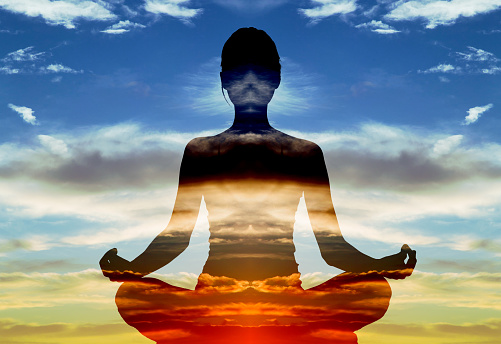 Double exposure of silhouette of woman doing yoga in lotus position over sunset sky. Concept of connection with the universe and nature.