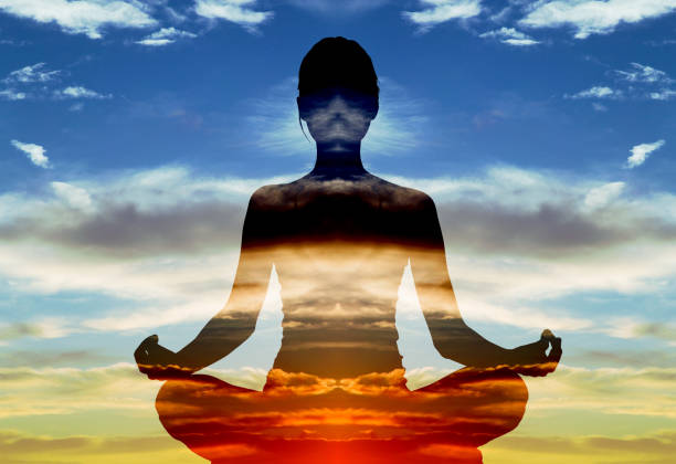Silhouette of woman doing yoga in lotus position over sunset sky. Concept of connection with the universe and nature. Double exposure of silhouette of woman doing yoga in lotus position over sunset sky. Concept of connection with the universe and nature. chakra photos stock pictures, royalty-free photos & images