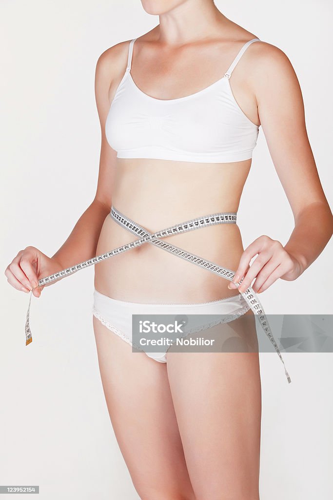 Femme mesurant sa taille - Photo de Abdomen libre de droits