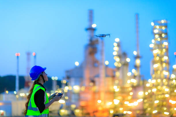 The female engineer using drone for top view inspection the refinery plant. The female engineer using drone for top view inspection the refinery plant. drone point of view stock pictures, royalty-free photos & images