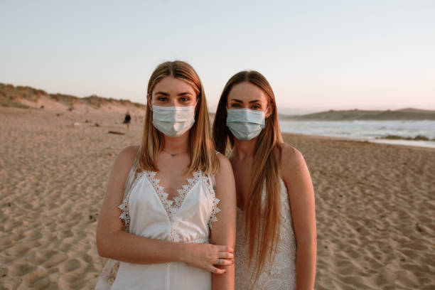 istock Two young women wearing face masks at beach 1239537084