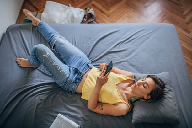 istock Beautiful woman using smart phone in bed 1239539206