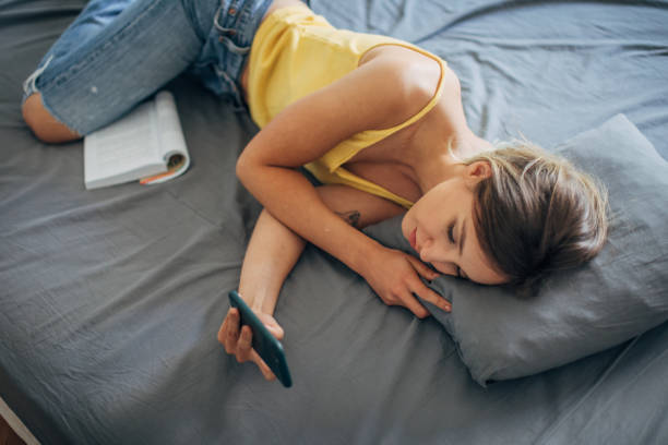 istock Beautiful woman using smart phone in bed 1239539745