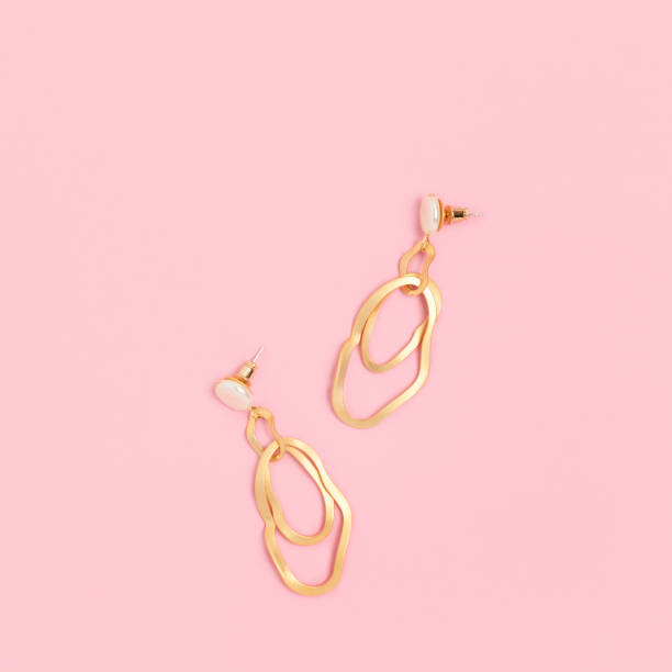 istock Golden earrings on a pink pastel background. 1239551526