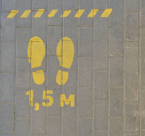 istock Markup yellow paint on paving slabs for social distancing. 1239554700