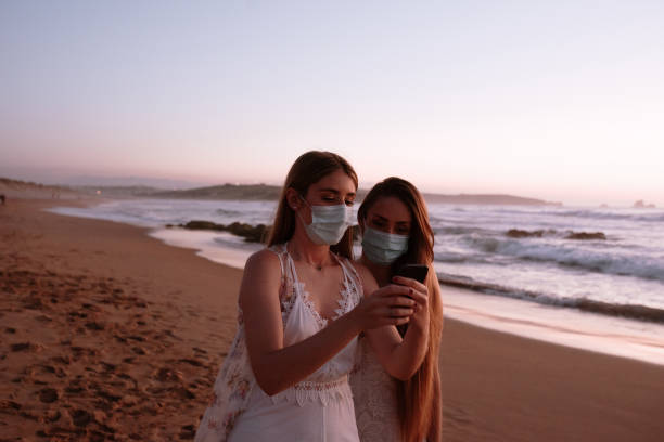 istock Two young women looking at a smart phone 1239561554