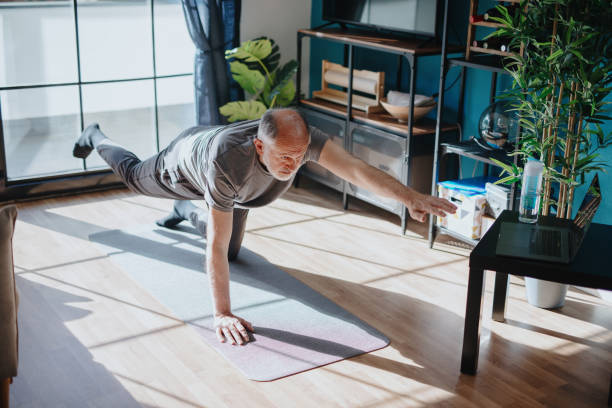 senior man doing balance exercise - senior adult sport yoga exercising imagens e fotografias de stock