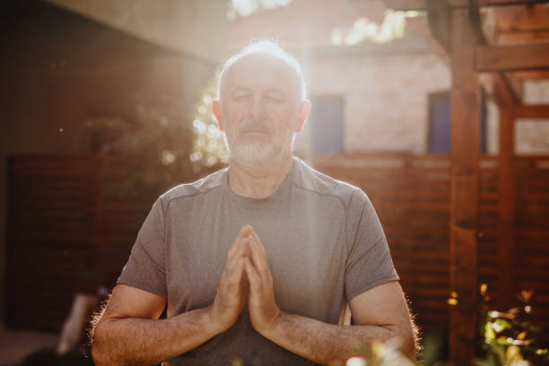 istock Active senior man standing with his palms together in meditation 1239571757