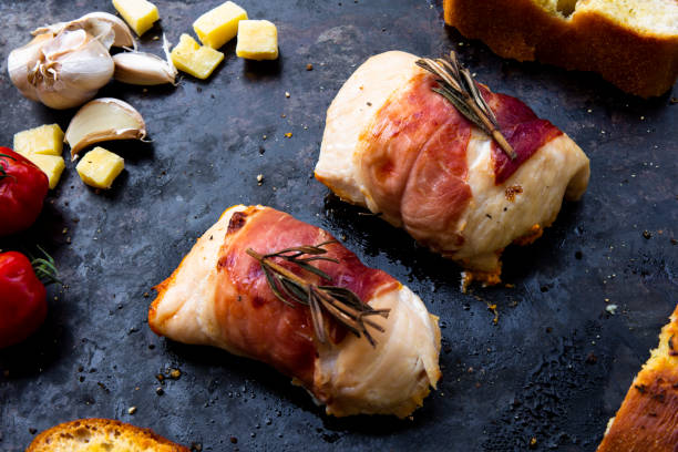 Prosciutto wrapped chicken breasts succulent chicken breasts filled with creamy parmigiana stuffing and wrapped in prosciutto with garlic bread bacon wrapped stock pictures, royalty-free photos & images