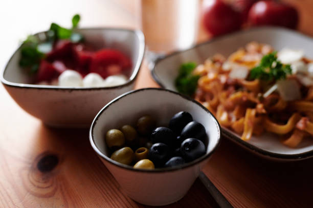 images of noodles with mozzarella cheese balls, tomatoes, and olives