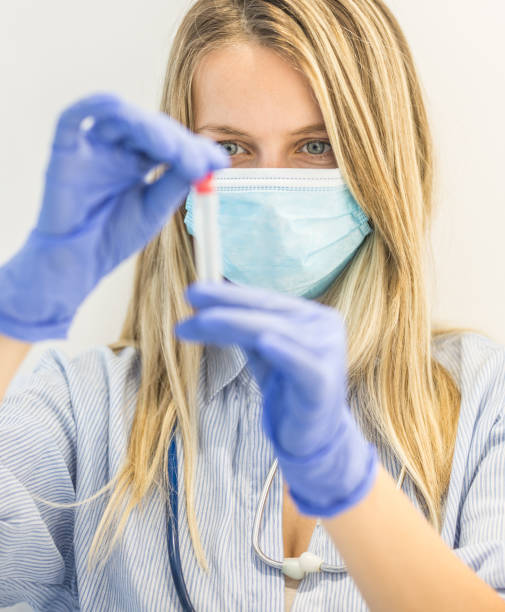 istock Nurse with mask holding test tube 1239591662
