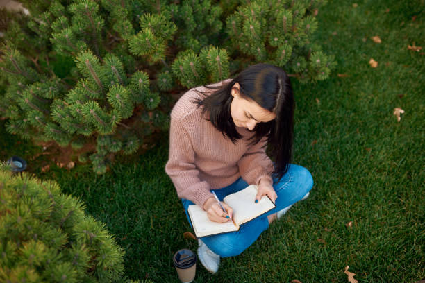 istock Concentrated young lady writing something important on a page 1239593274