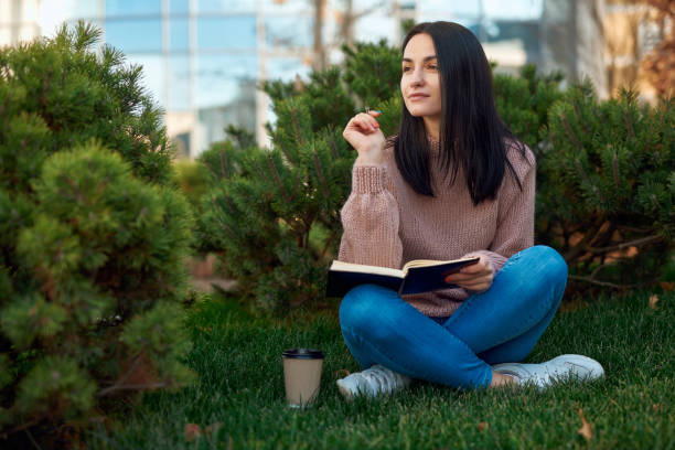 istock Pretty young lady studying outdoors in the park 1239593276