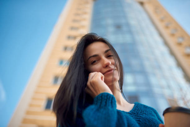 istock Young smiling brunette using her smartphone outdoors 1239596026