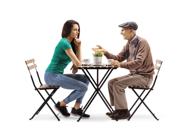 istock Young woman sitting at a table with an elderly man 1239611897