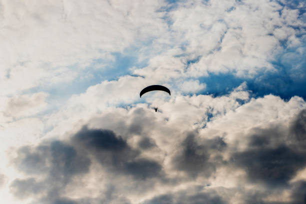 istock paraglider silhouette in front of a dark cloudy sky 1239626510