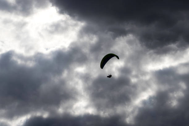 istock paraglider silhouette in front of a dark cloudy sky 1239626518