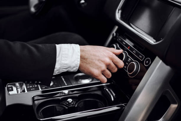 istock Businessman changing turning button radio stations on his automobile 1239636726